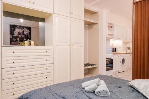 a white bedroom with a bed and a kitchen at Thalia Luxury Apartment in Samos