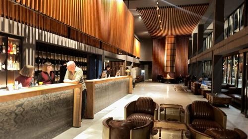 a man standing at a bar in a restaurant at Gudauri Loft Apartment N508 in Kʼumlistsʼikhe