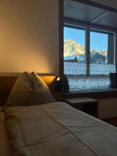 a bedroom with a bed and a window with a mountain view at Ciasa Valiares in San Vigilio Di Marebbe