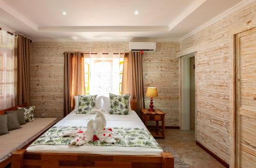 a bedroom with a bed with stuffed animals on it at Ambiance Villa in La Digue