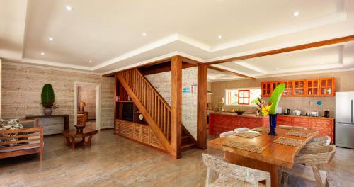 a kitchen and living room with a wooden table at Ambiance Villa in La Digue