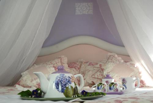 a table with a tea set on a bed at La Dimora le Fumarole Rooms in Ercolano