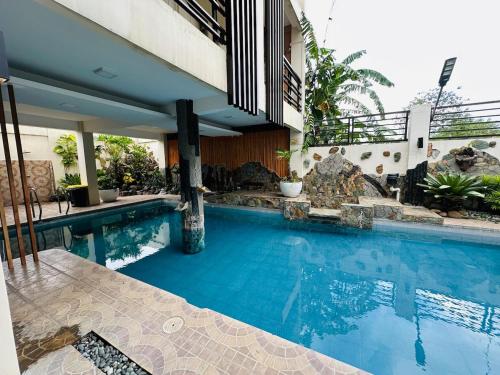 a swimming pool next to a house at Alta Montana One Hotspring Resort Mt Makiling View in Forestry