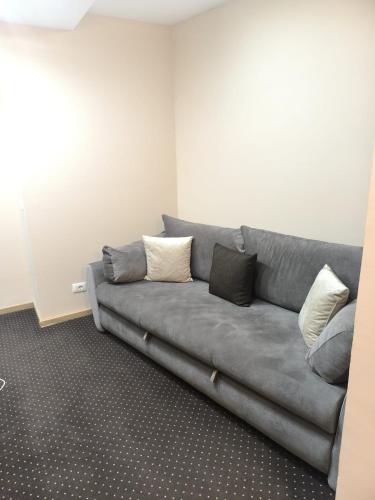 a grey couch with pillows in a living room at Angella Centar Lux Apartmani Kopaonik in Kopaonik