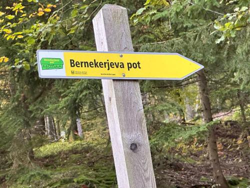 a yellow sign on a wooden post at Apartments Barbra - Robinson life in Slovenj Gradec