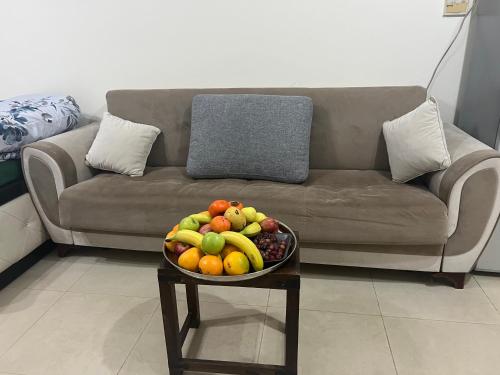 a bowl of fruit on a table in front of a couch at Pure zamzam Guest House At Al nahda Sharjah Dubai Border-FAMILY ONLY in Sharjah
