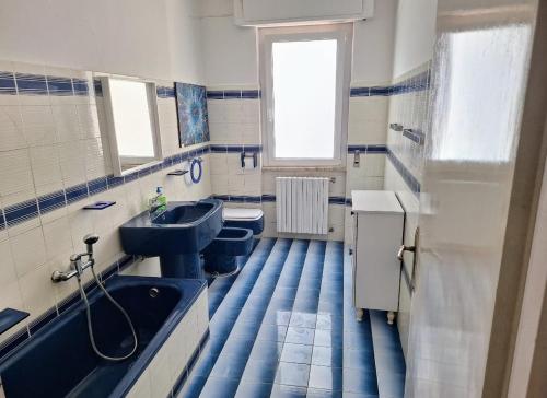 een blauwe en witte badkamer met 2 toiletten en een bad bij CasaWhite in San Vito Chietino