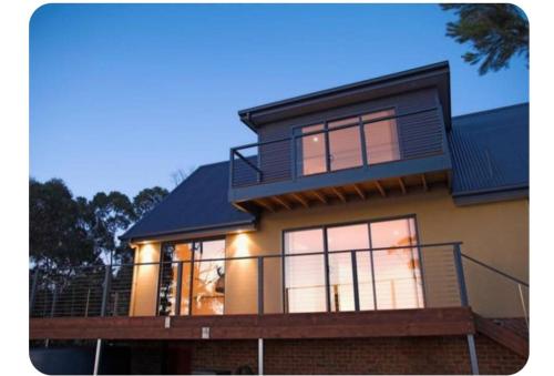 a large house with a balcony on top of it at The Cove in Huon Island