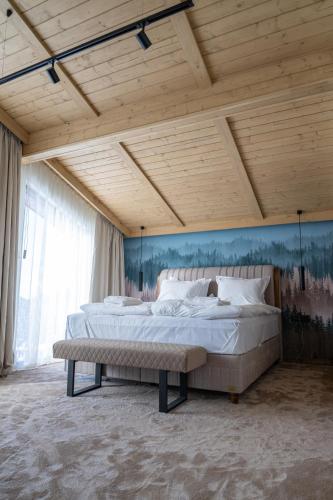 a bedroom with a large bed and a wooden ceiling at Chalet Pamporovo in Pamporovo