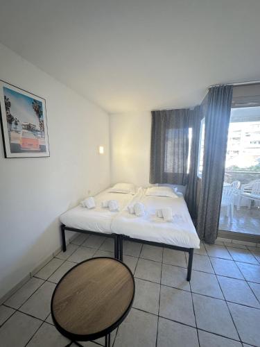 une chambre avec un lit, une table et une fenêtre dans l'établissement Résidence Graziella Studio 324, à Juan-les-Pins