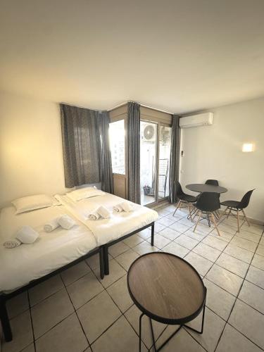 une chambre avec deux lits et une table et des chaises dans l'établissement Résidence Graziella Studio 324, à Juan-les-Pins