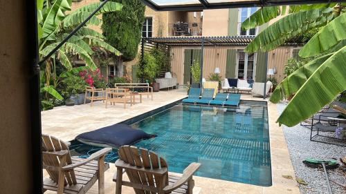 a swimming pool with chairs and a table at Maison Jacotte orange in Orange