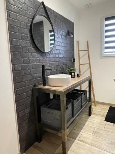 une salle de bain avec un lavabo et un miroir dans l'établissement Chambres à 20minutes du circuit des 24h du mans, à Soulitré