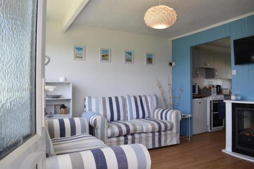 een woonkamer met 2 stoelen en een bank bij 46 Hectors, Sunbeach, Scratby - Two bed chalet, sleeps 4, pet friendly, free Wi-Fi, free entry to onsite clubhouse and bed linen and towels included in Great Yarmouth
