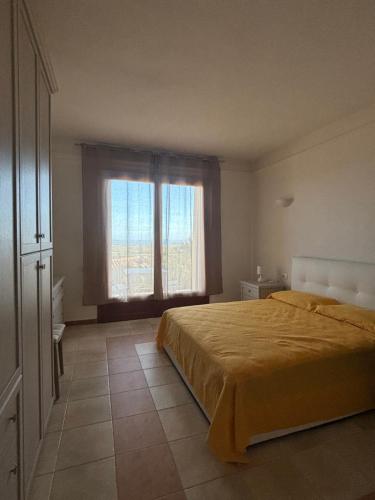 Un dormitorio con una cama y una ventana grande. en Sunrise Golf, en Is Molas 