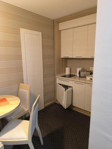 a small kitchen with a table and a table and chairs at Konaci Kopaonik Lux Apartmani in Kopaonik