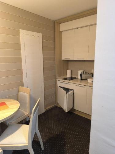 a small kitchen with a table and a table and chairs at Konaci Kopaonik Lux Apartmani in Kopaonik