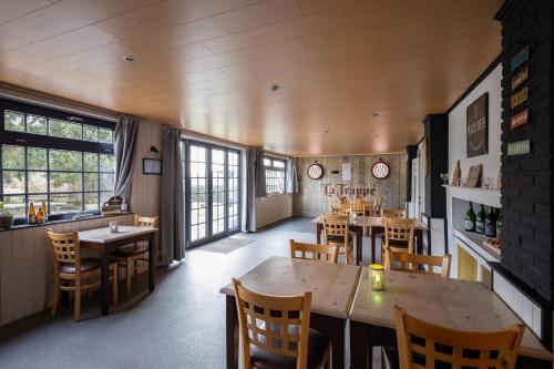 a restaurant with wooden tables and chairs and windows at Bed & Breakfast The Place 2 Beer in Bullange