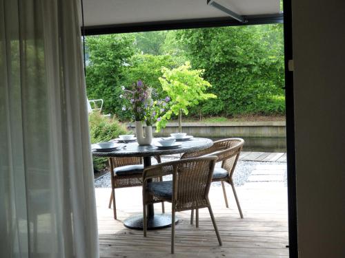 a table with chairs and a vase of flowers on a patio at Immer simmer in Lemmer