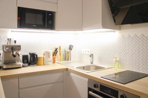 a kitchen counter with a sink and a microwave at Bright and comfortable 28m2 Studio in Vanves in Vanves