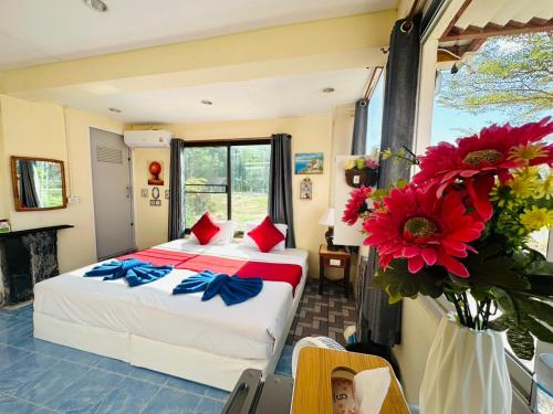 a bedroom with a bed and flowers in a room at House 2 Bedroom full river view near beach in Ko Chang