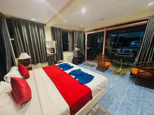 a bedroom with a large bed with red and blue sheets at House 2 Bedroom full river view near beach in Ko Chang