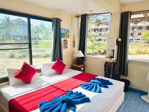 a bedroom with a large bed with red and blue pillows at House 2 Bedroom full river view near beach in Ko Chang