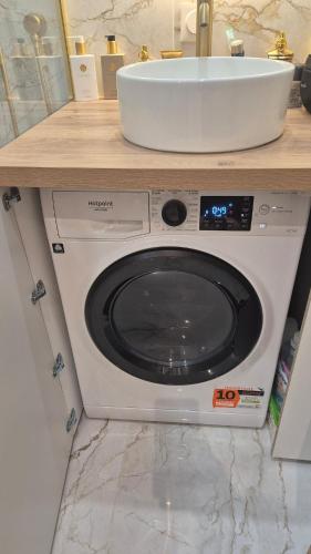 - un lave-linge sous un comptoir avec évier dans l'établissement L 'Écrin Cosy with Private Terrace, à Brétigny-sur-Orge