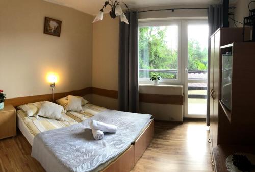 a bedroom with a bed with towels on it at Pensjonat Klaudia in Ostrowo