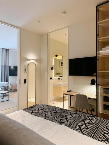a bedroom with a bed and a desk with a computer at MrSTiL Design Aparthotel in Berlin