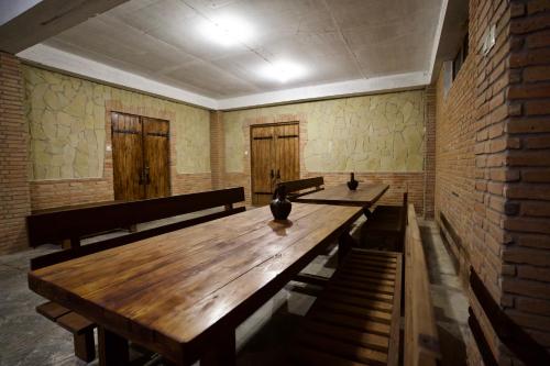 a room with a long wooden table and benches at Hotel Mogzauri in Tbilisi City