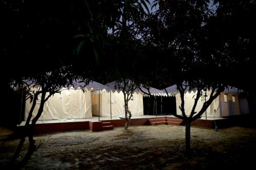 a white building with trees in front of it at Mango Farm Villa in Thūr