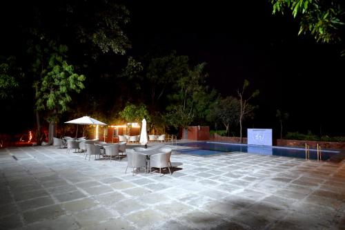 a patio with tables and chairs at night at Mango Farm Villa in Thūr