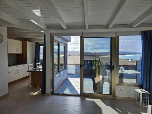 a kitchen with sliding glass doors and a view of the ocean at Apartamento (Cotillo Mar) con vistas al Mar in Cotillo