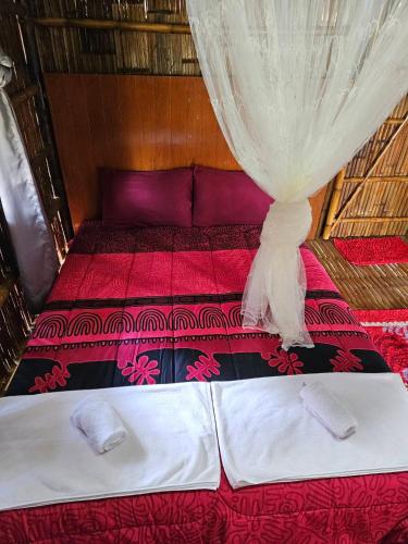 a bedroom with a bed with a curtain on it at Rommai Forest Bungalows in Ko Lanta