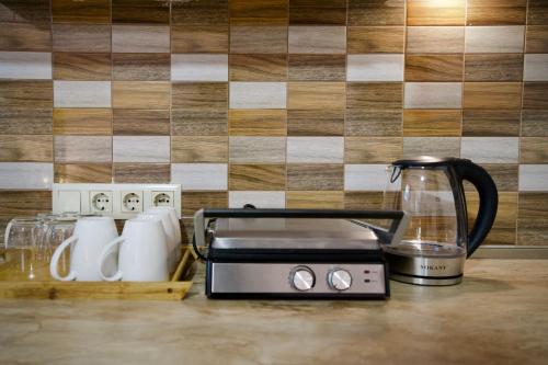 a counter with a toaster and a coffee maker on it at Hotel Mogzauri in Tbilisi City