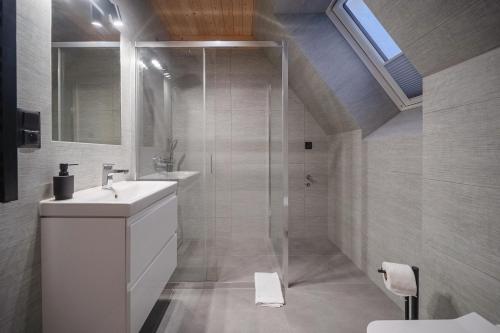 a white bathroom with a sink and a shower at Apartamenty Kozica&Jeleń in Witów
