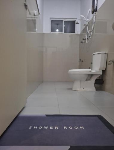 a bathroom with a toilet and a shower room at Zeleny Retreat Home Stay in Matara