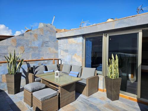 a patio with wicker chairs and a table at Apartamento (Cotillo Mar) con vistas al Mar in Cotillo