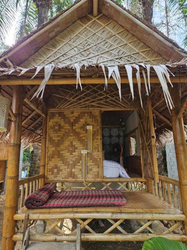 a bed in a bamboo house with a roof at Rommai Forest Bungalows in Ko Lanta
