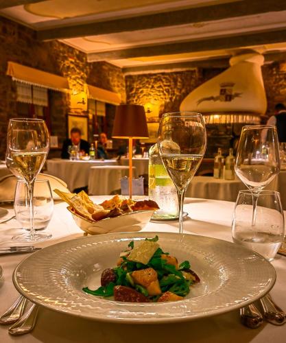 a plate of food on a table with wine glasses at Casale in Collina in Capriva del Friuli