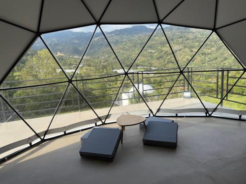 a room with two chairs and a table in a glass building at The Wolf Glamping in Tenza