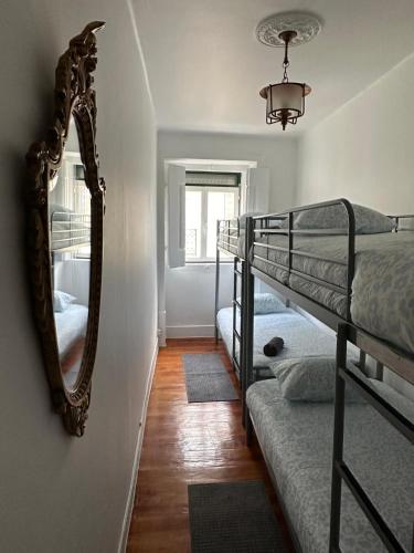 a bedroom with two bunk beds and a mirror at Lisboa Príncipe Real Home - Casa de Hóspedes in Lisbon