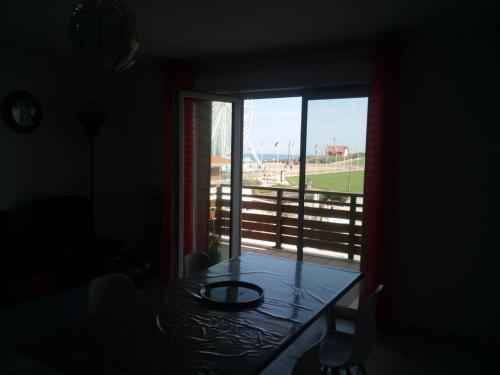 une pièce avec une table et une fenêtre avec vue dans l'établissement Les pieds dans l'eau salée, à Biscarrosse