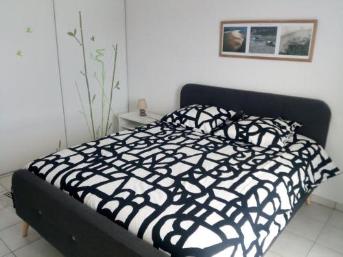 - un lit noir et blanc dans une chambre blanche dans l'établissement Les pieds dans l'eau salée, à Biscarrosse