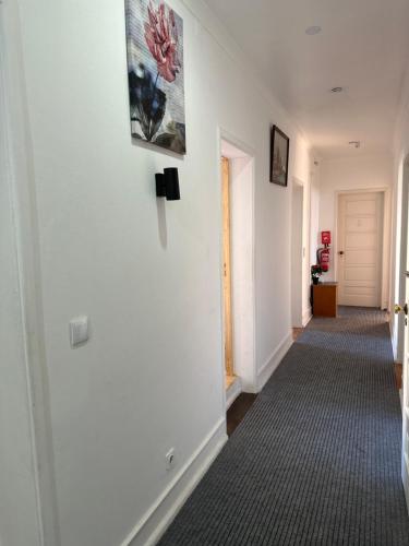 a hallway with a white wall with a picture on the wall at Rose view guest house in Lisbon