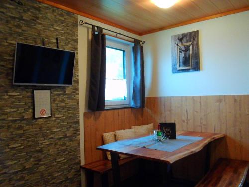 FlattnitzにあるApartment Alpenstille Flattnitzの壁にテーブルとテレビが備わる部屋