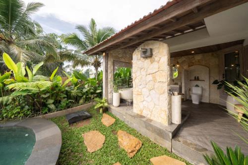 a house with a bathroom and a swimming pool at Legong Sebatu Villa in Ubud