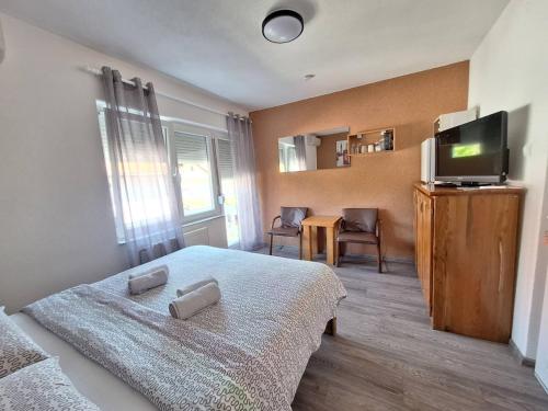 a bedroom with a bed and a television and a table at Sobe-Apartmani Modriča in Modriča