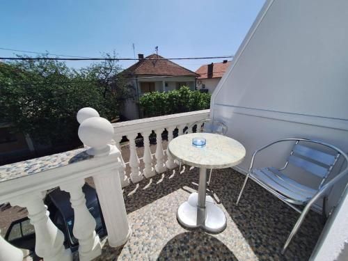a small table and a chair on a balcony at Sobe-Apartmani Modriča in Modriča